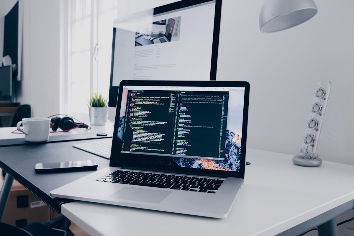 Developer coding a website on a laptop in a modern workspace